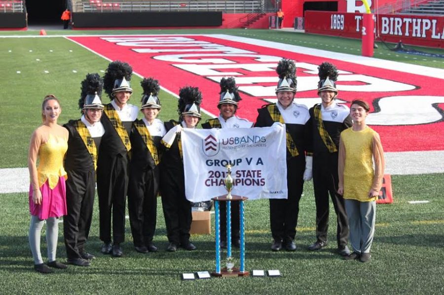 Above: Leaders of the Highlander Band accept the State Championship award, as well as several category awards.. Photo Courtesy: Peter Suckiel via Facebook 
