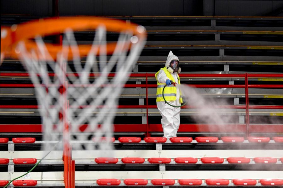 A person cleans the seats of an empty stadium with no fans inside and no sports going on at the time