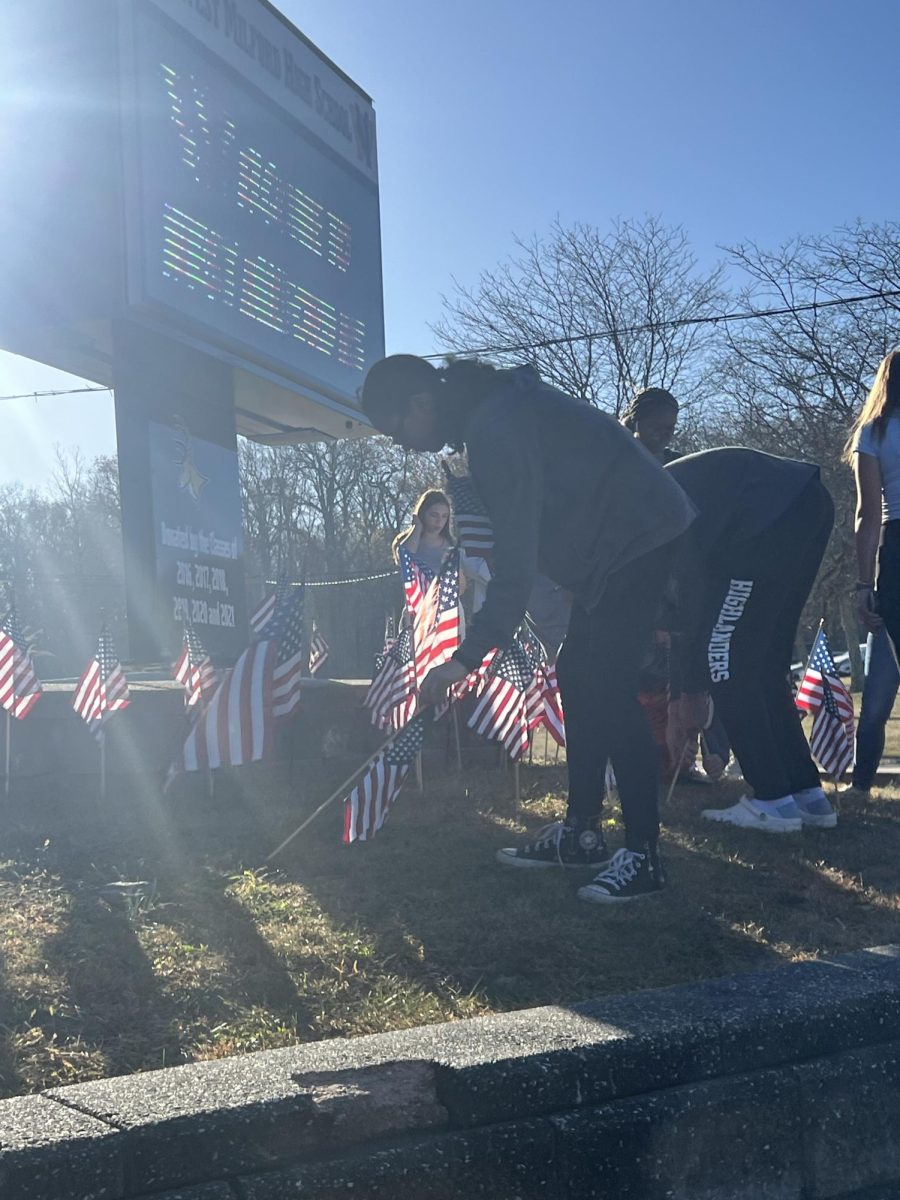 Students from Mrs. Petrosillo's 2nd period class place the flags outside the high school by the digital sign. 